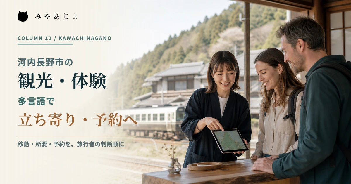 山あいの鉄道路線に近い観光案内所で事業者が旅行者へ行程を案内するイメージ