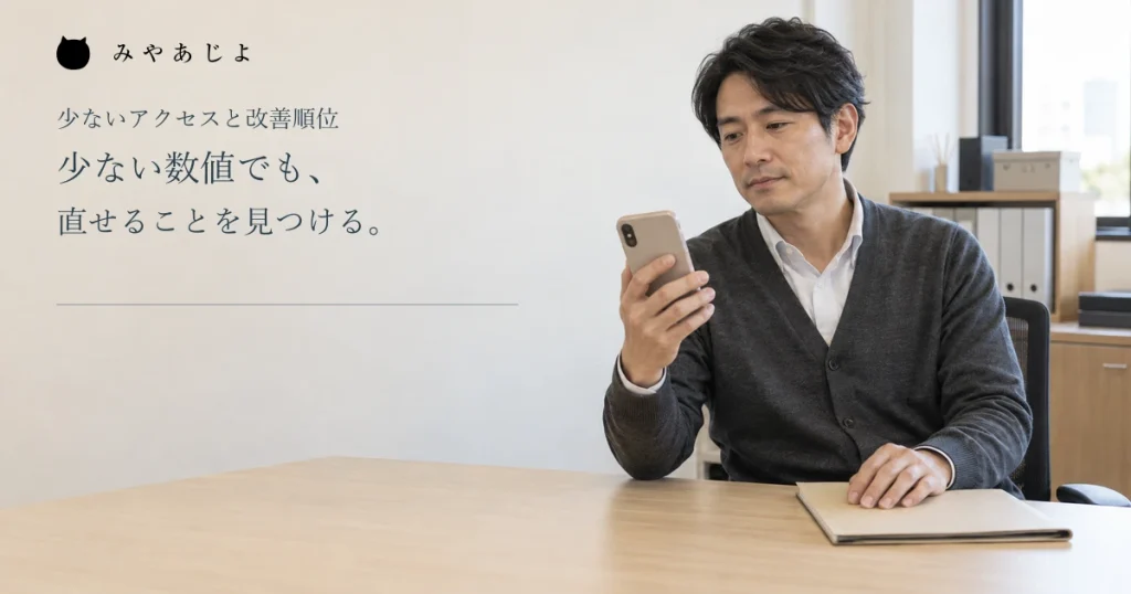 少ない数値でも直せることを見つけるという見出しと、会社でスマートフォンを確認する男性