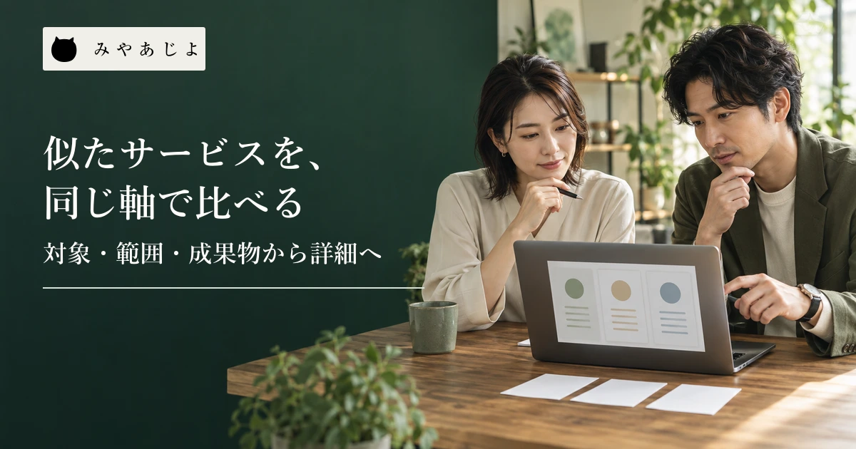 二人のWeb担当者が三列のサービス比較案をノートパソコンと紙で確認する場面