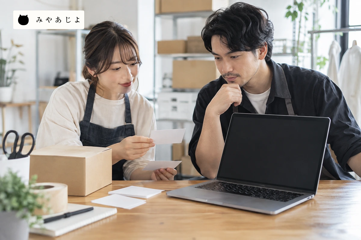 成人EC運営担当者が無地の商品の注文カードと返品案内の配置を確認する場面