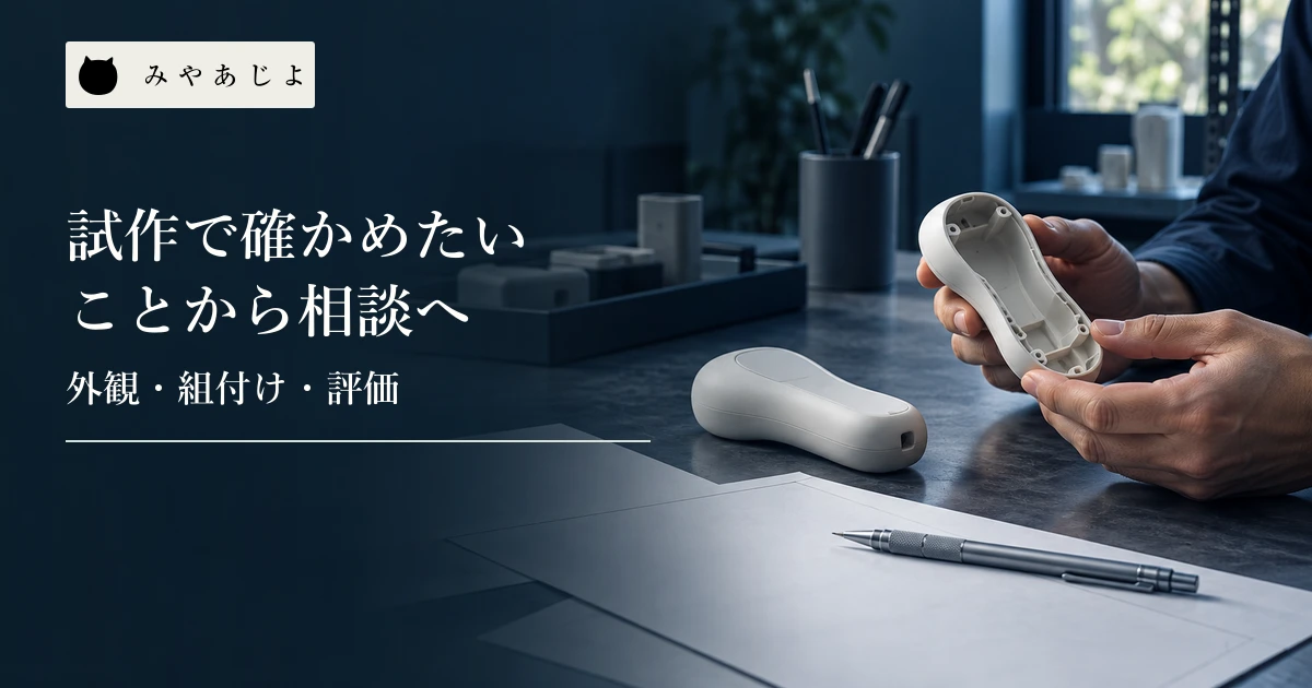 樹脂の外装サンプルと白紙の設計用紙を机上で確認する技術担当者の手元