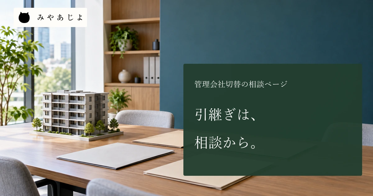 管理会社の事務所で、無記名の四つの資料フォルダーと建物模型を置いた机