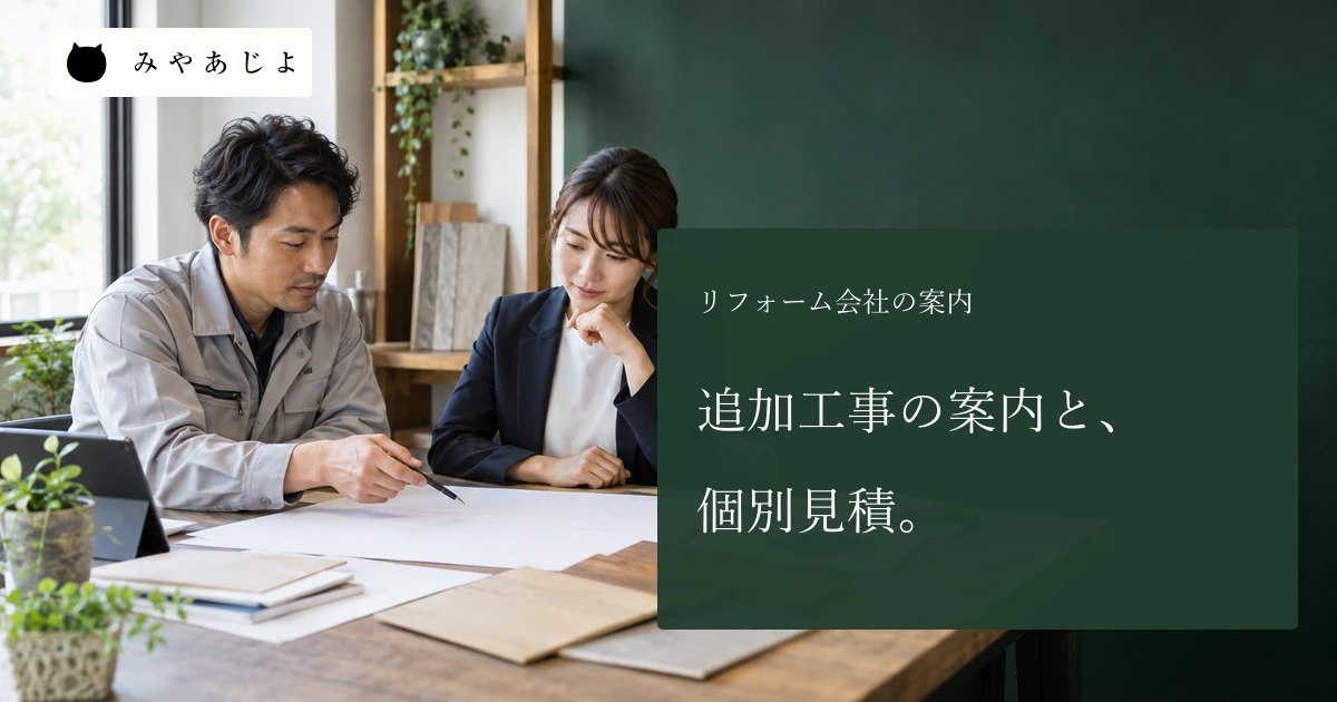 リフォーム会社で成人の担当者二人が白紙の図面と色見本を確認する場面