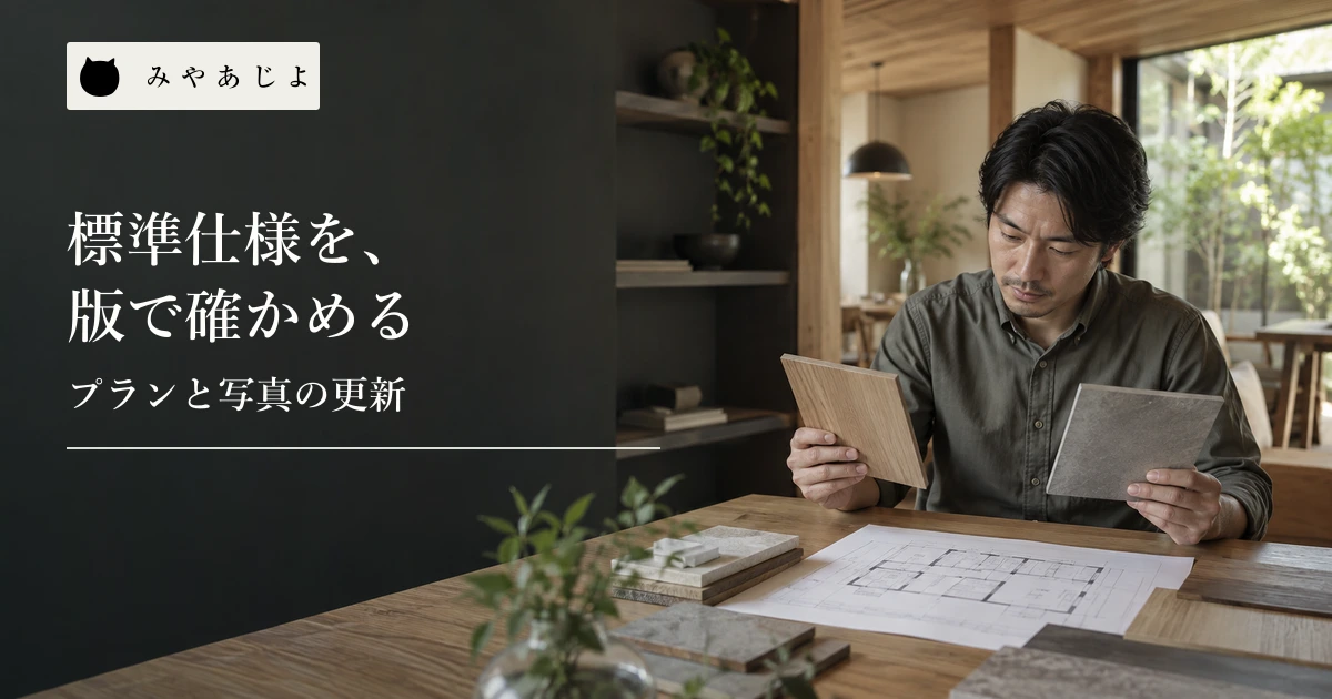 住宅設計の担当者が木材と石材の見本を図面の上で見比べる場面