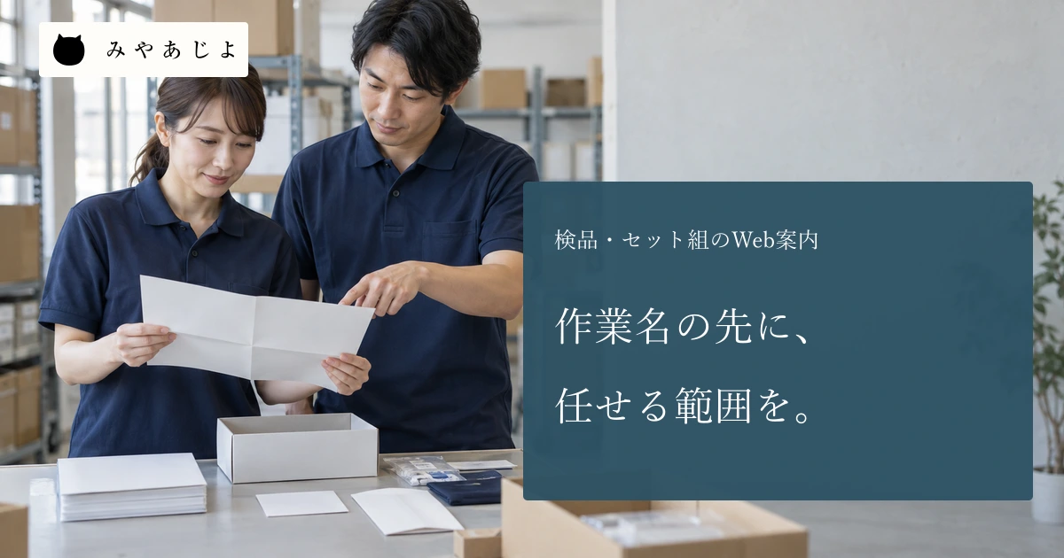倉庫の成人担当者二人が無記名の冊子・カード・封筒と指示を作業台で確認する場面