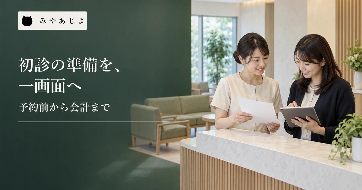 クリニックの受付担当者とWeb担当者が待合を背景に無記名の初診案内を確認する場面