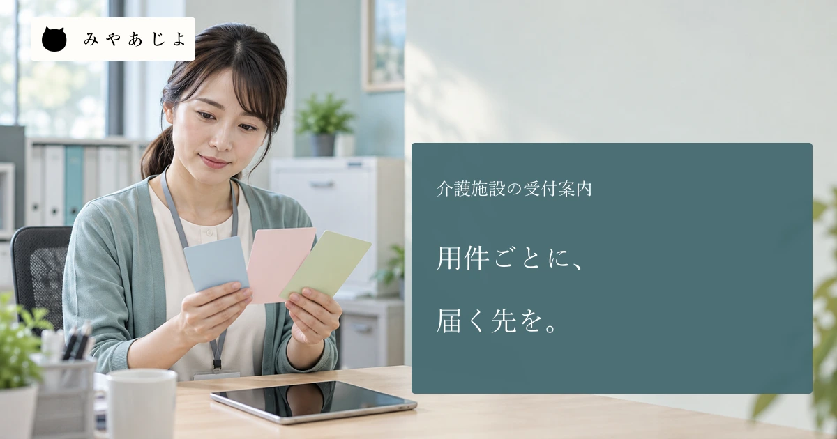 成人介護事業所スタッフが無地の受付案内カードと白紙の画面案を確認する場面