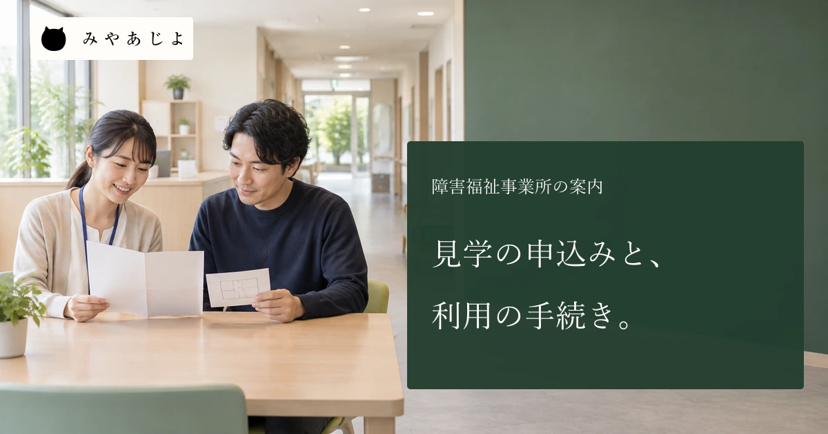 障害福祉事業所で成人の受付担当者二人が無記名の見学案内を確認する場面