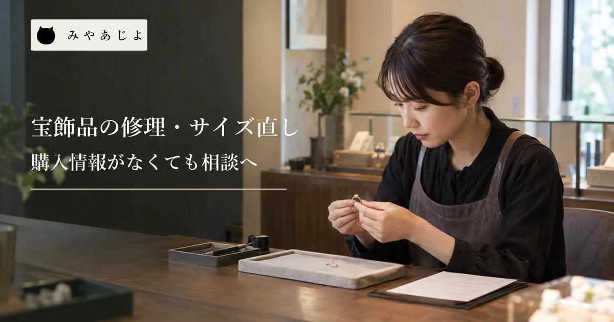 宝飾店のカウンターでスタッフが指輪を確認する場面