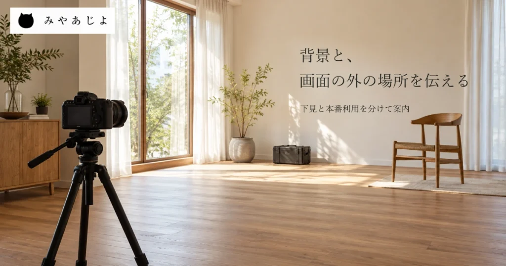 架空の撮影向け室内を横から広く見て、手前の無記名カメラと三脚、奥の窓と椅子、閉じた機材ケースと空いた床を一緒に写し、背景と画面の外の場所を伝える見出しを添えた撮影場所サイトのイメージ