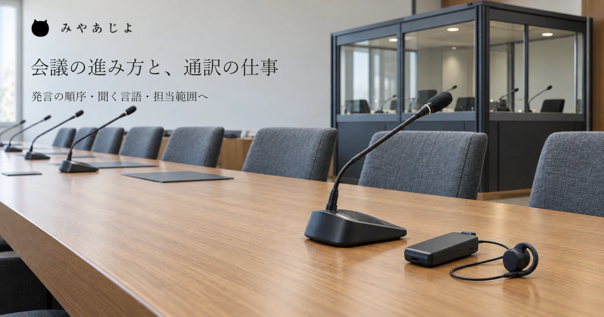 普通の空の会議室のマイクと無記名の音声受信機・イヤホン、奥の通訳ブースを自然な光で見せ、会議の進み方と通訳・音声の担当範囲を考える写真イメージ