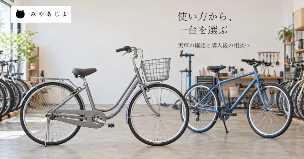 普通の自転車店のかご付き車とスポーツ車、奥の整備道具を自然な光で見せ、使う場面から車種選びと購入前後の相談を考える写真イメージ