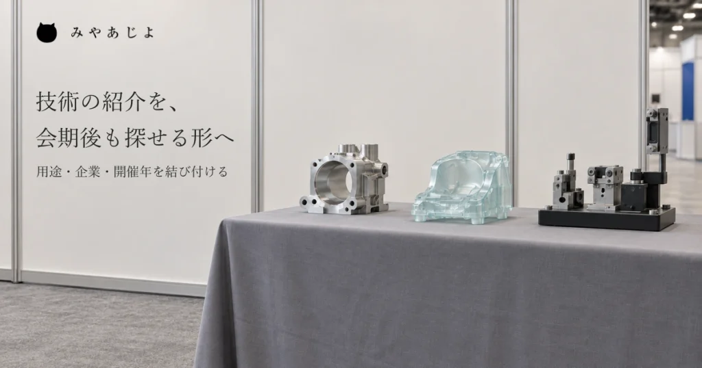 普通の架空の合同展示の場所で金属部品、樹脂試作品、検査用治具を同じ観点で見比べられるよう並べ、用途と企業・開催年を結ぶ案内を考える自然な写真イメージ