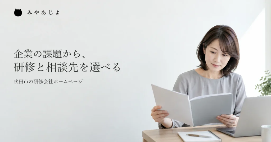 研修の案内担当者が、講座の資料とノートパソコンを見ながら説明を考える一般的な作業イメージ