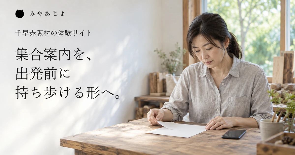 体験の受付に備え、紙の案内とスマートフォンを机で確かめる運営者
